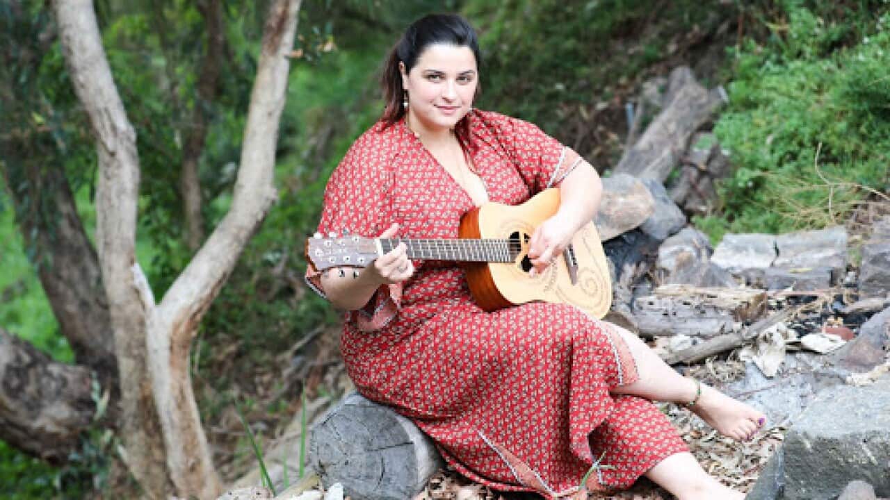 Marija Janev, a Macedonian musician from Melbourne, playing on her guitar