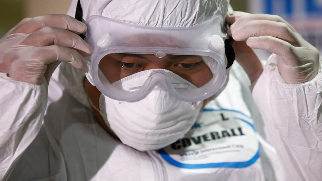 An emergency responder of the Quezon City Disaster Risk Reduction and Management Office wears protective gear in Quezon City, Philippines.