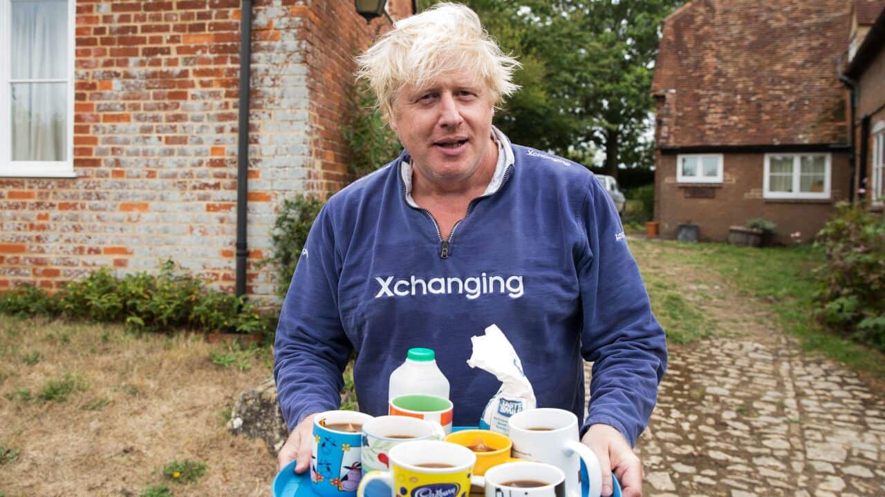 Boris Johnson brings tea for the press to drink outside his house in Thame.. Picture date: Sunday August 12, 2018.