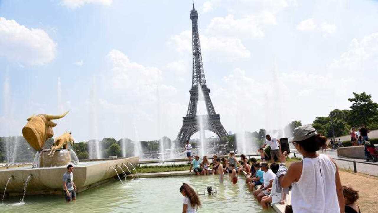 People cool down at the Fontaine du Trocadero in front of The Eiffel Tower in Paris, France, on July 26, 2018, as the French capital is placed on heatwave alert as temperatures are set to soar in the coming days.