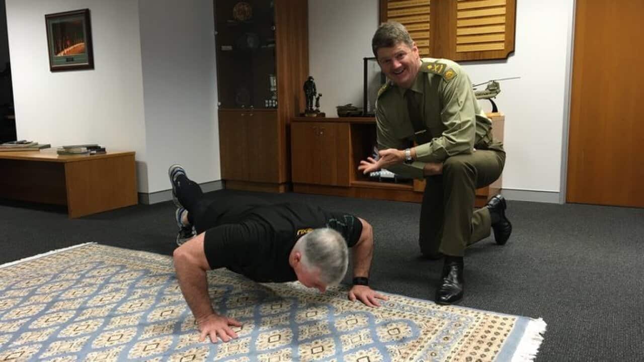 Bill Sowry doing his push ups as Acting chief of Australian Army, Gen Gus McLachlan keeps count