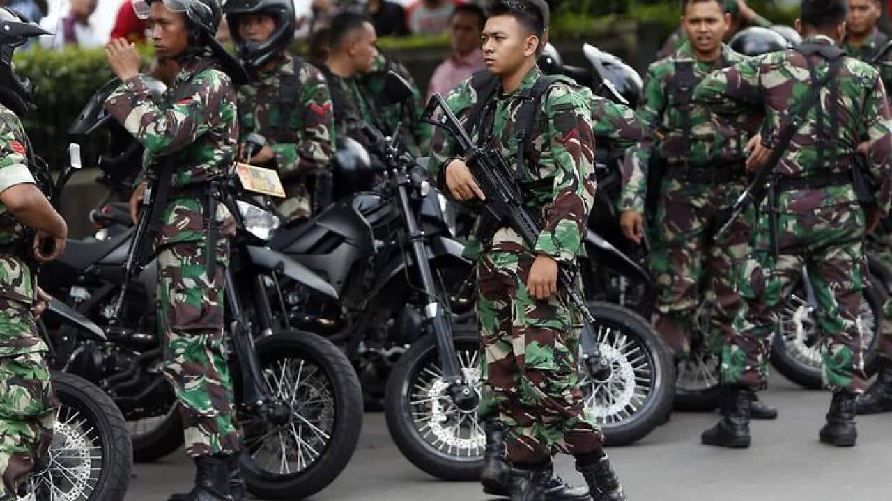 Armed Indonesian soldiers stand guard after gunfire and bomb blasts in front of a shopping mall in Jakarta, Indonesia, 14 January 2016. (AAP)
