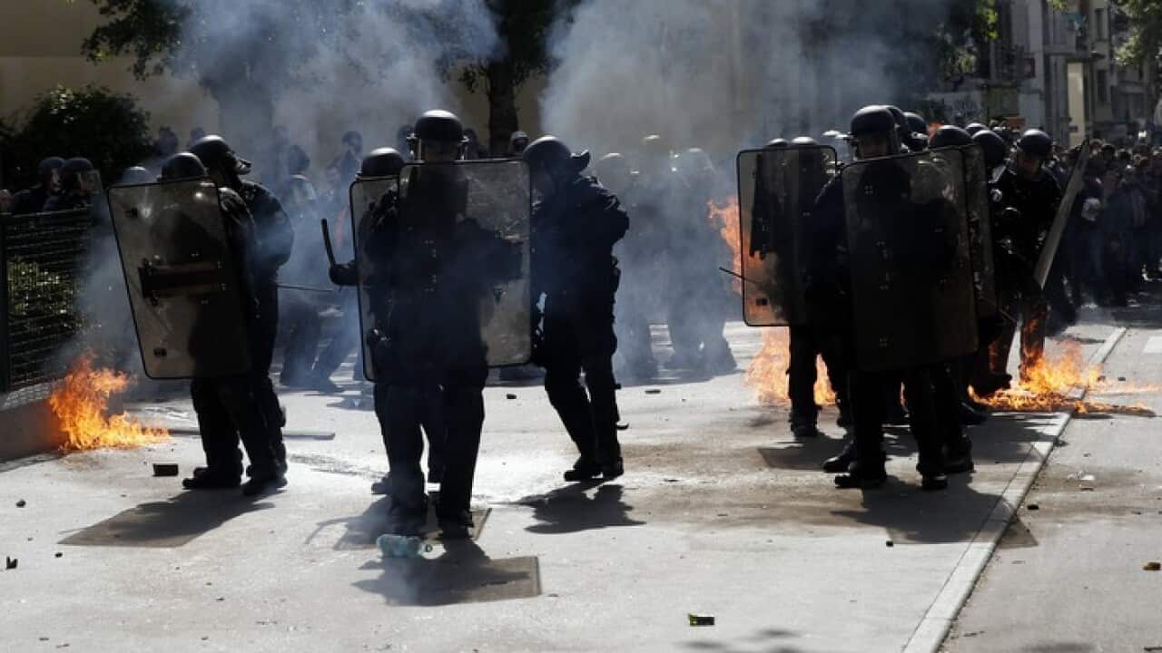 French police shield themselves as projectiles and molotov cocktails are thrown at May Day protests