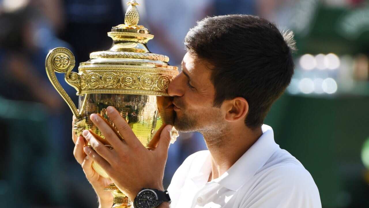 Novak Djokovic of Serbia lifts the championship trophy after beating Kevin Anderson of South Africa in the men's singles final