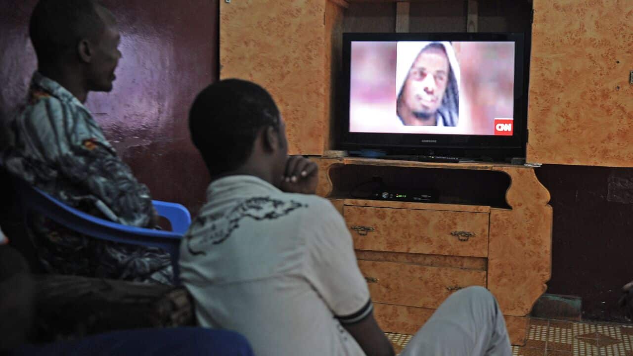 Somali men watch news announcing death of Shebab leader