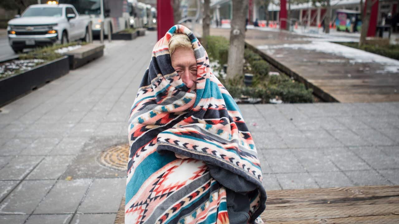 A woman bundles up in a blanket to stay warm at the George R. Brown Convention Center, Tuesday, Feb. 16, 2021, in Houston.