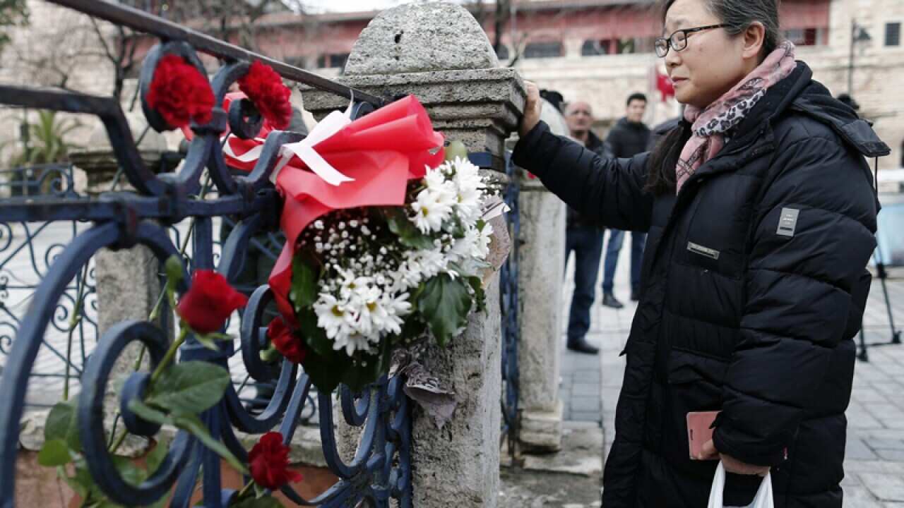 A woman places a flower for victims in Sultanahmet