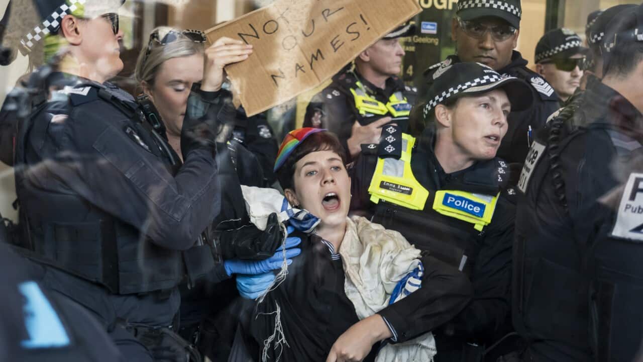 Police remove a protester from a building.