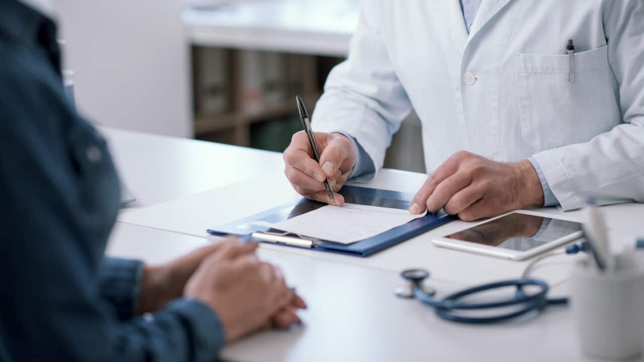 Doctor writing a medical prescription for his patient