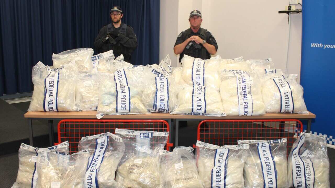 Police officers stand near packages containing illicit drugs during a press conference in Sydney on November 29, 2014.