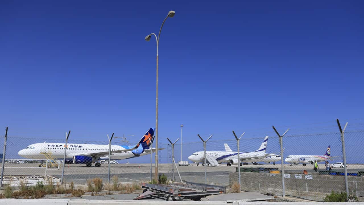 Penny Wong speaking at a lectern with the Australian, Aboriginal, and Torres Strait Islander flags behind her