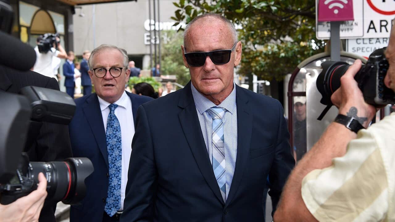Chris Dawson (centre) leaves Downing Centre Local Court in Sydney on Wednesday.