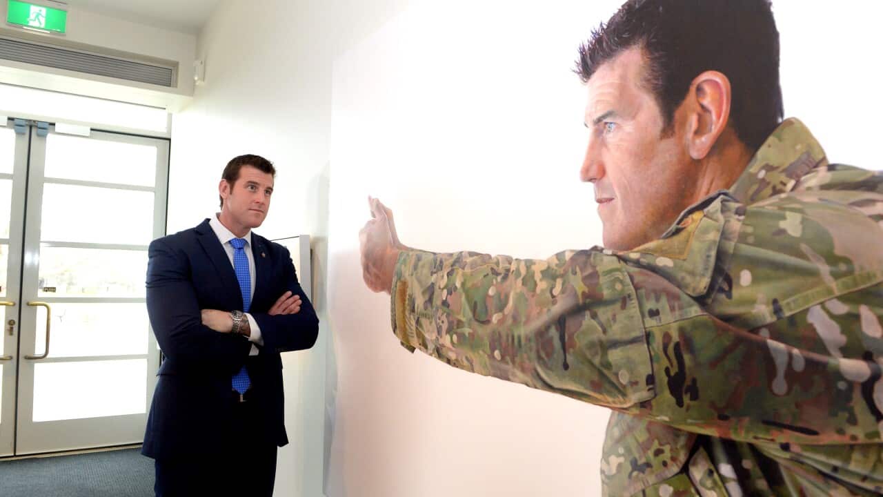 Man look at painting of himself.