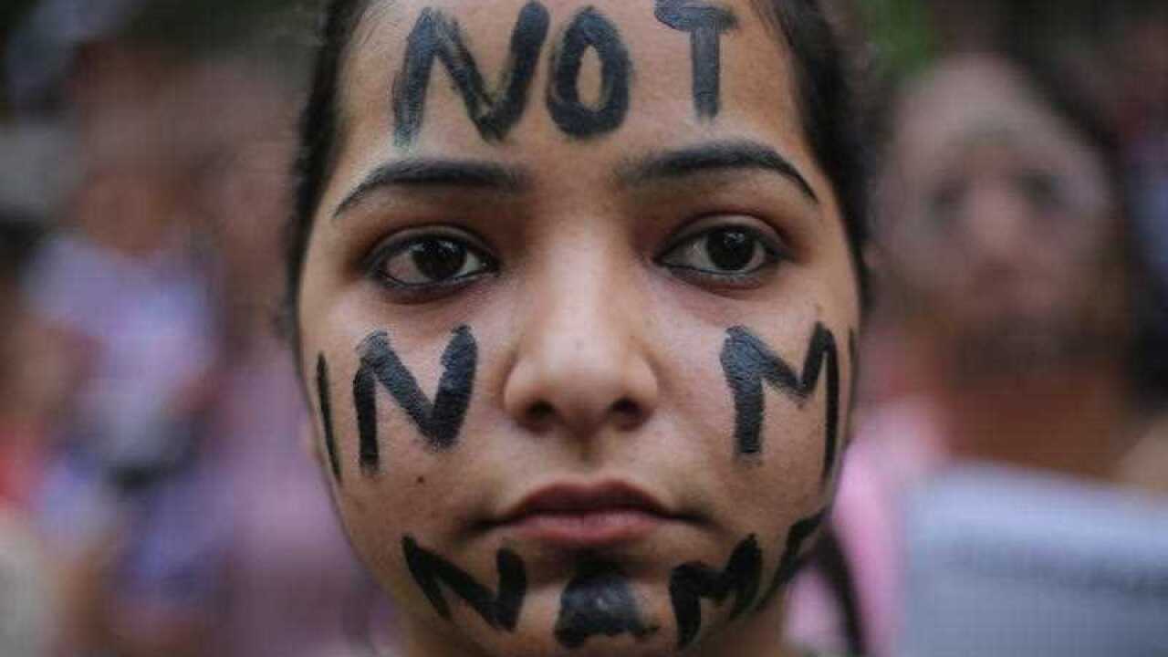 A participant has the words "not in my name" painted on face during a protest against two reported rape cases in India