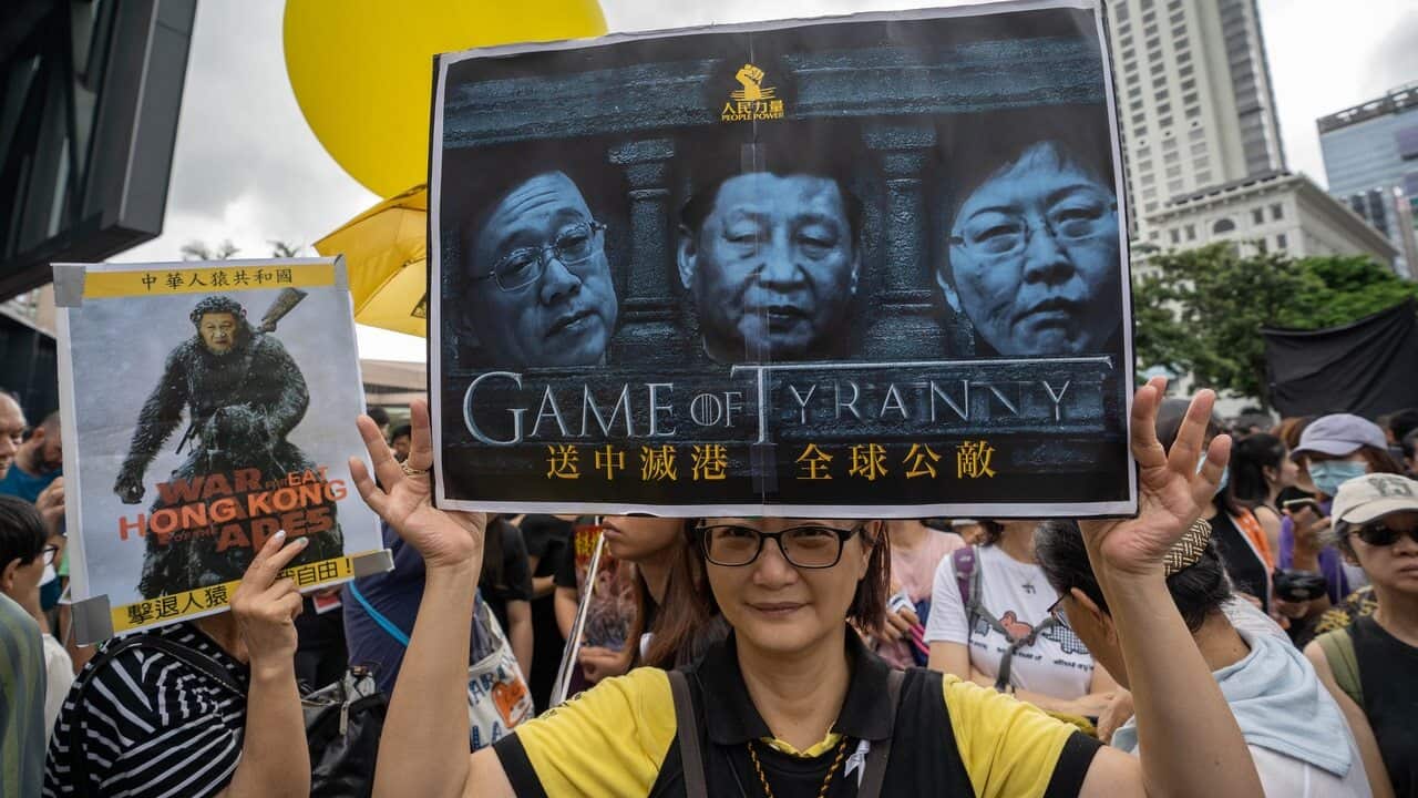 A protester holds a placard with the portraits of Xi Jinping, Carrie Lam and the Chief Secretary for Administration of Hong Kong Matthew Cheung.