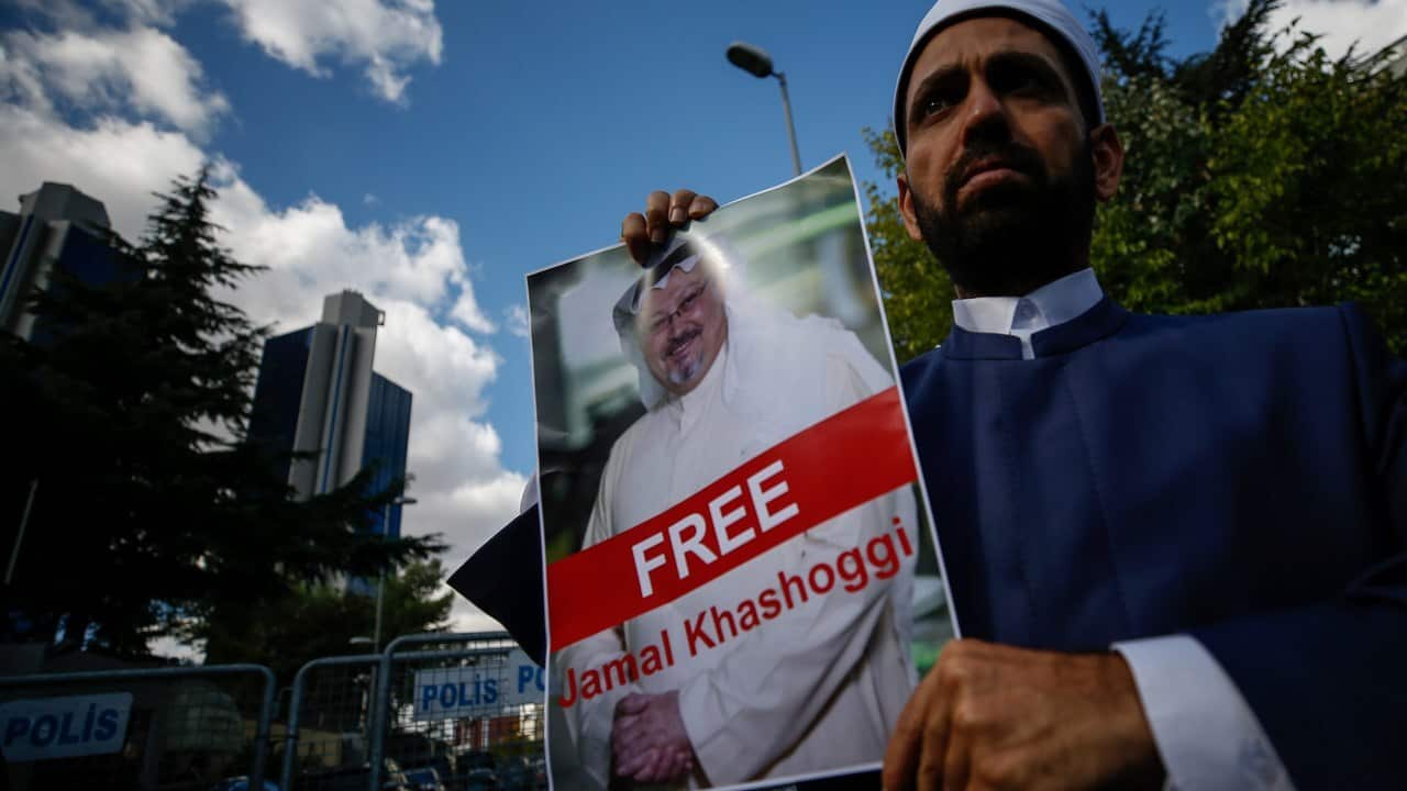 Holding a poster of missing Saudi writer Jamal Khashoggi, a man stands near the Saudi Arabia consulate in Istanbul.