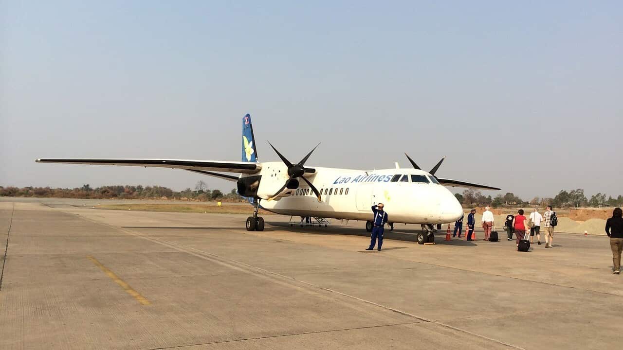 Passengers walk to a Lao airplane