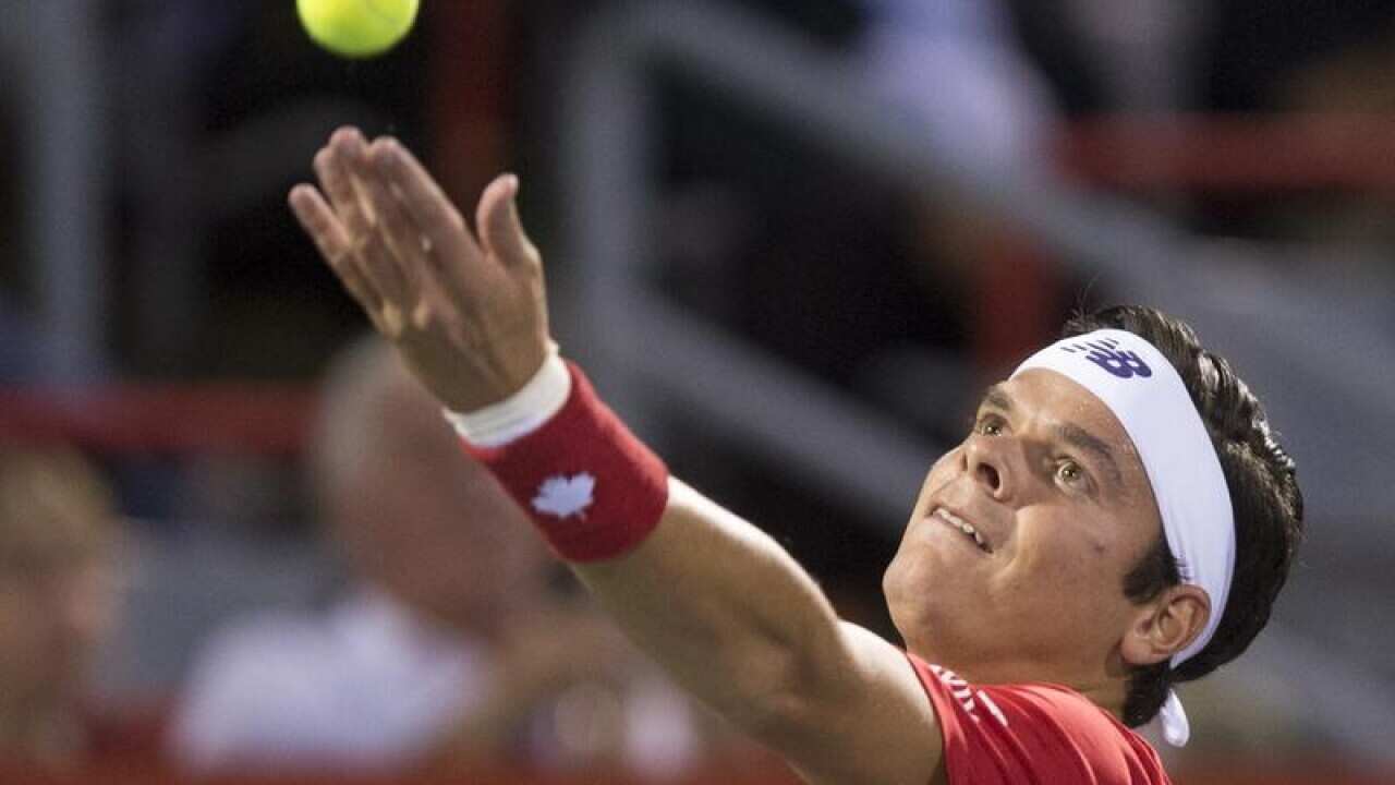 Milos Raonic of Canada tosses the ball to serve.