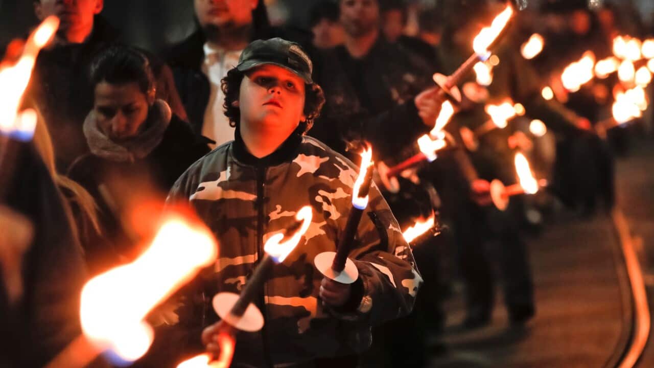 A child holds a flare as people take part in the "Lukov March," staged by the far-right Bulgarian National Union, in Sofia, Bulgaria, Saturday, Feb. 16, 2019.
