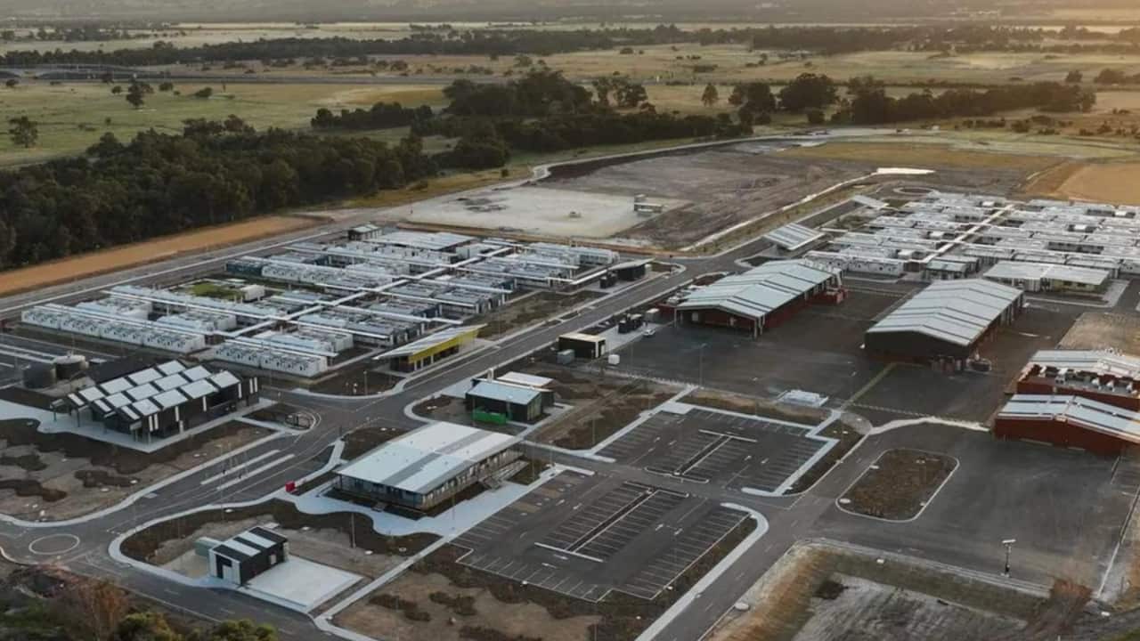 An aerial view of a low level buildings with a parking lot.