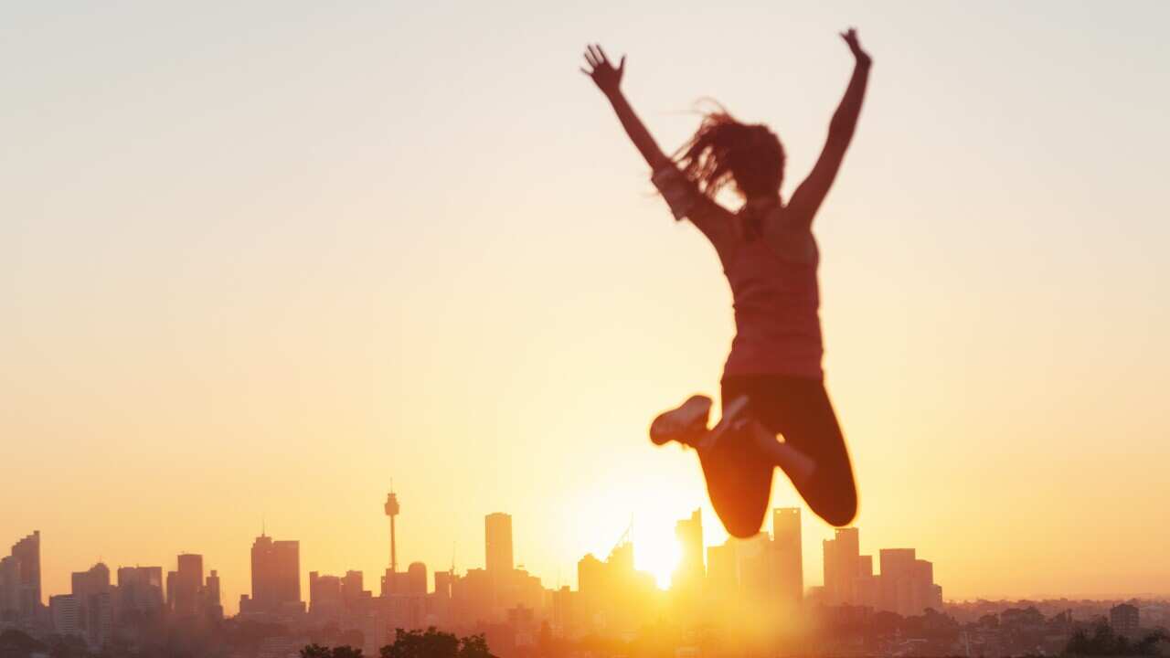 Sport women jumping and celebrating with arms raised.