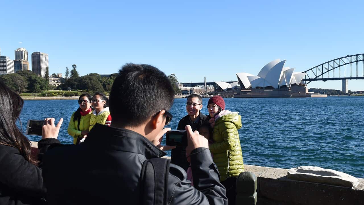 Tourists take photos in Sydney.