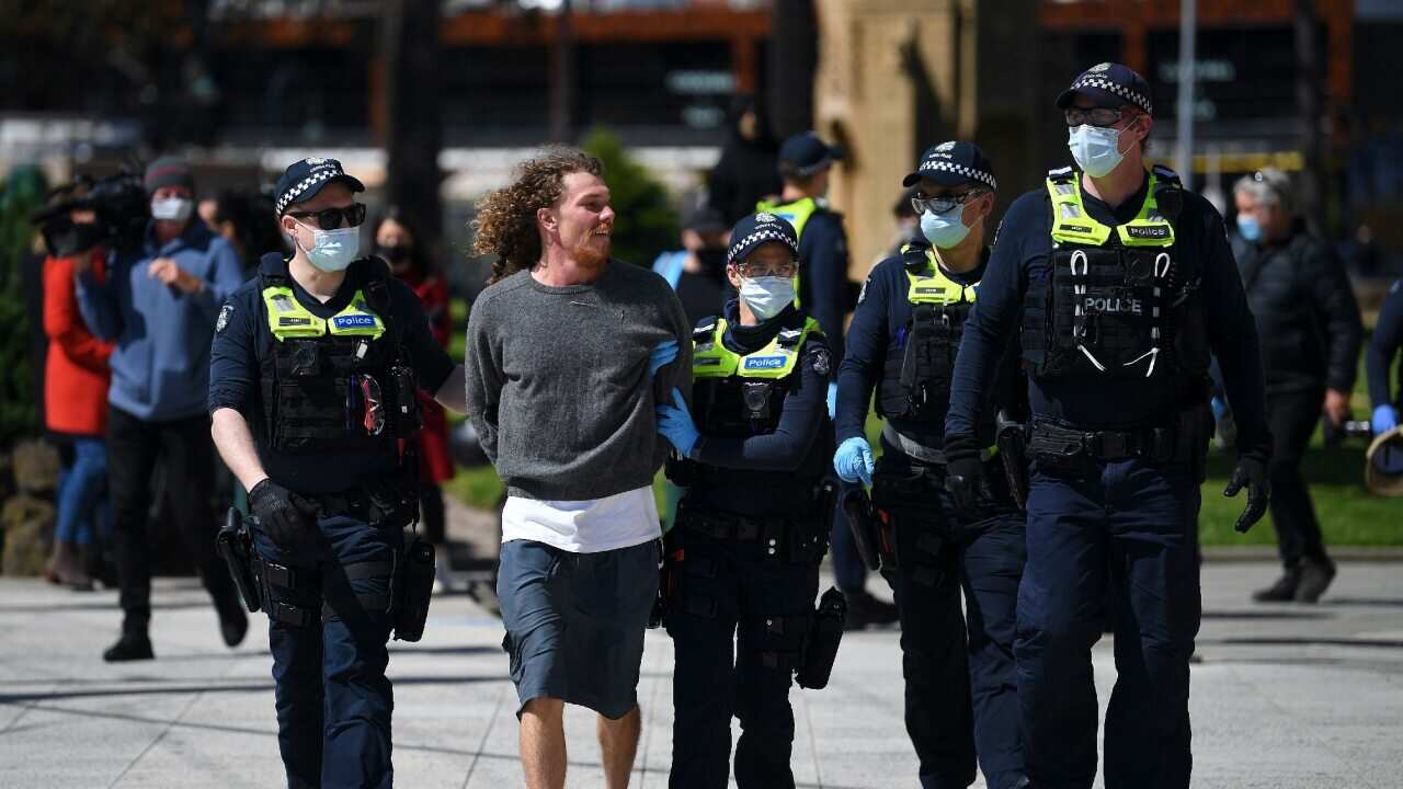 Victorian Police officers arrest an anti-lockdown protester in Melbourne.