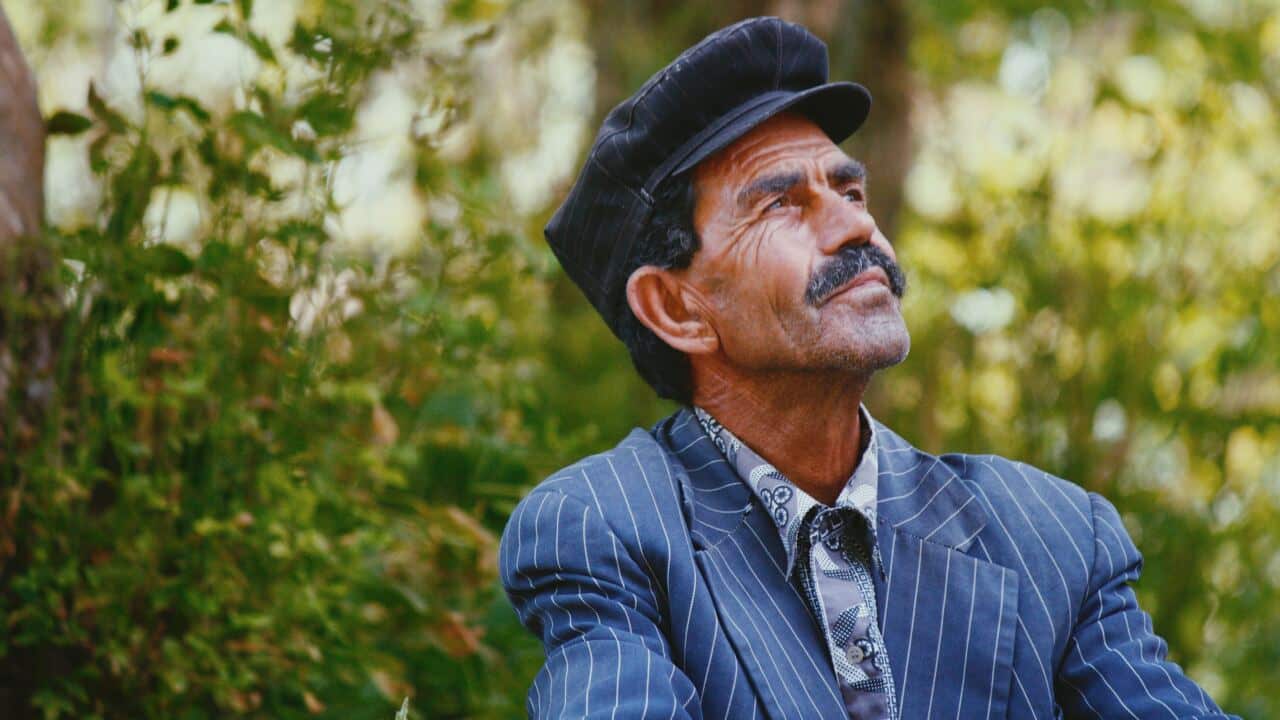 Man with mustache looks up at sky