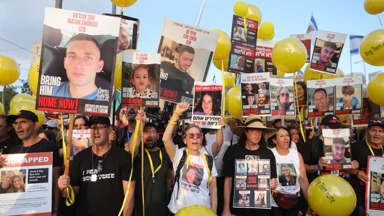 A crowd of people holding up pictures and signs