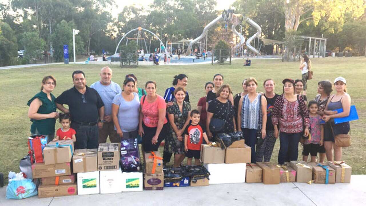 Refugee families from Syria and Iraq receive hampers in a park in Fairfield. PHOTO: Milan Maksimovic