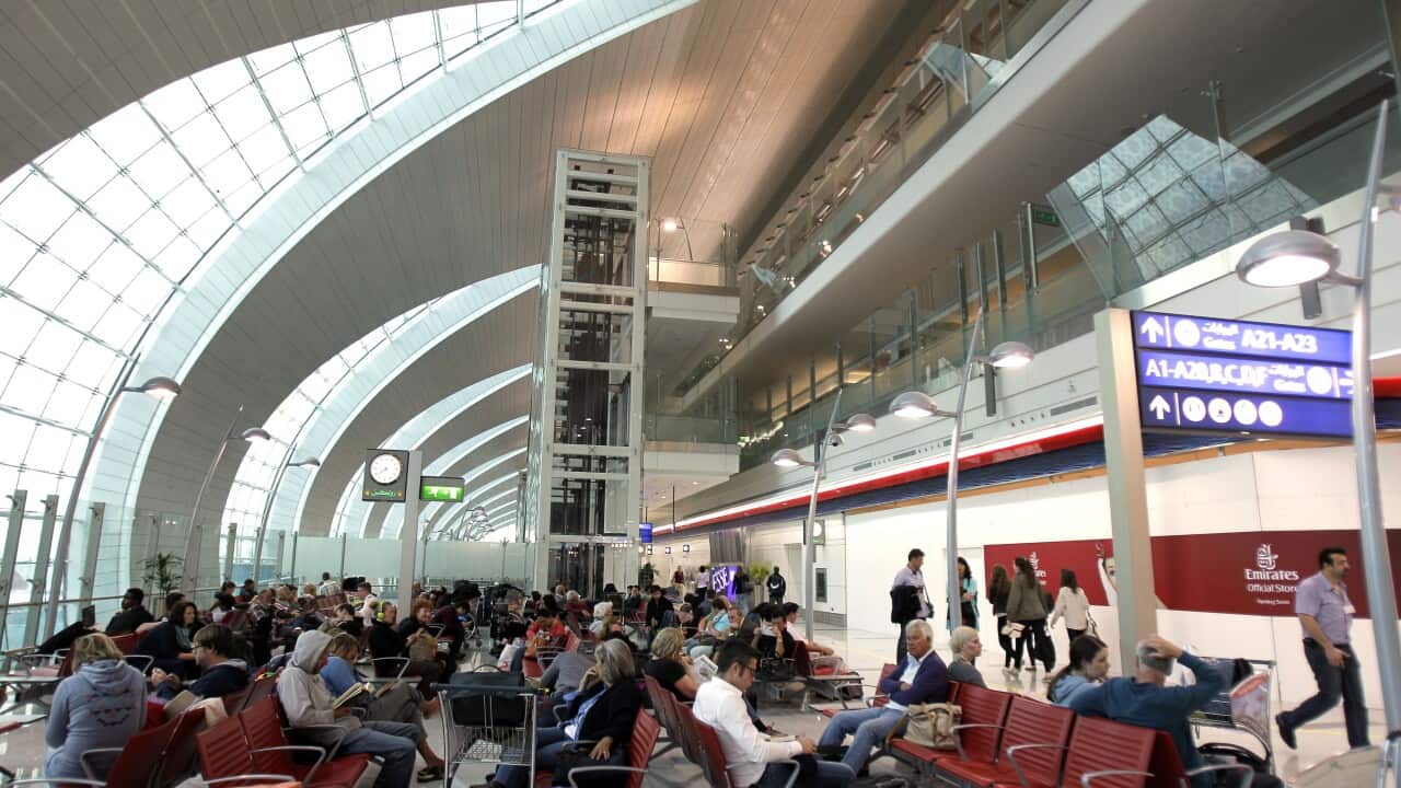 Passengers wait to board a flight at Dubai airport