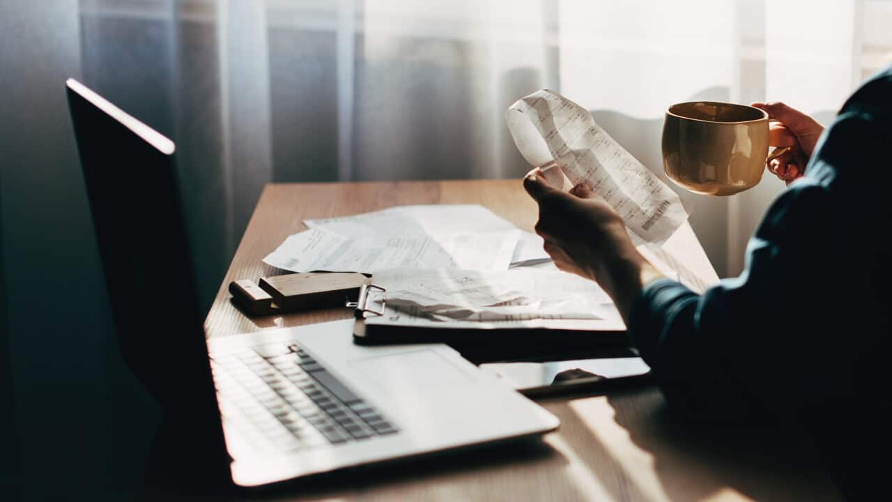 Person looking at receipts in front of their computer