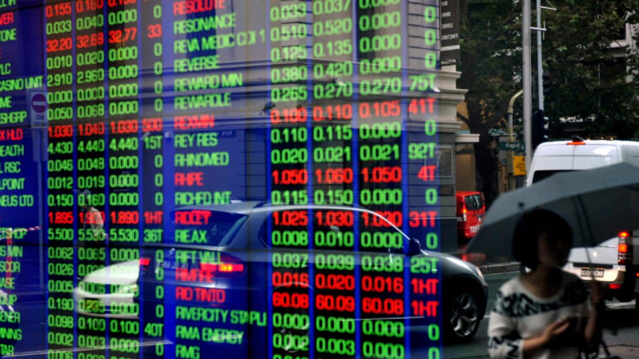 Pedestrians are reflected in a window at the Australian Stock Exchange