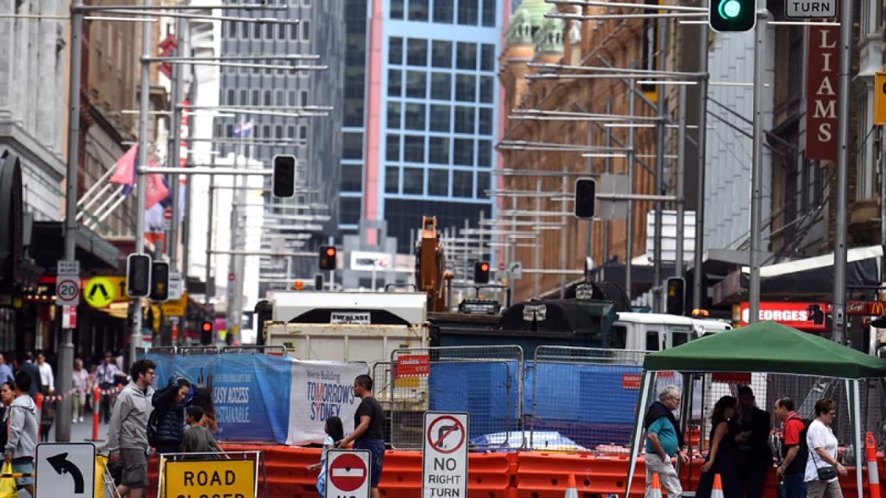 Pedestrians walk past a closed off George Street in Sydney's CBD