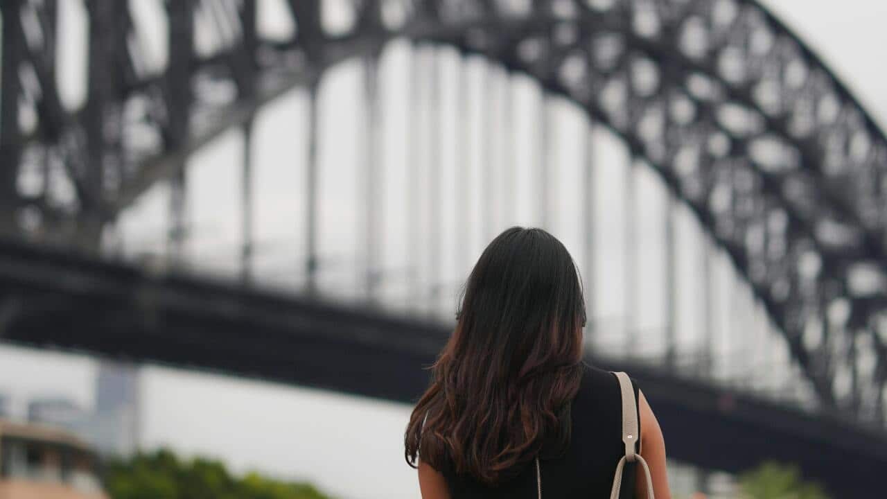 A woman viewing the Sydney Harbour Bridge.