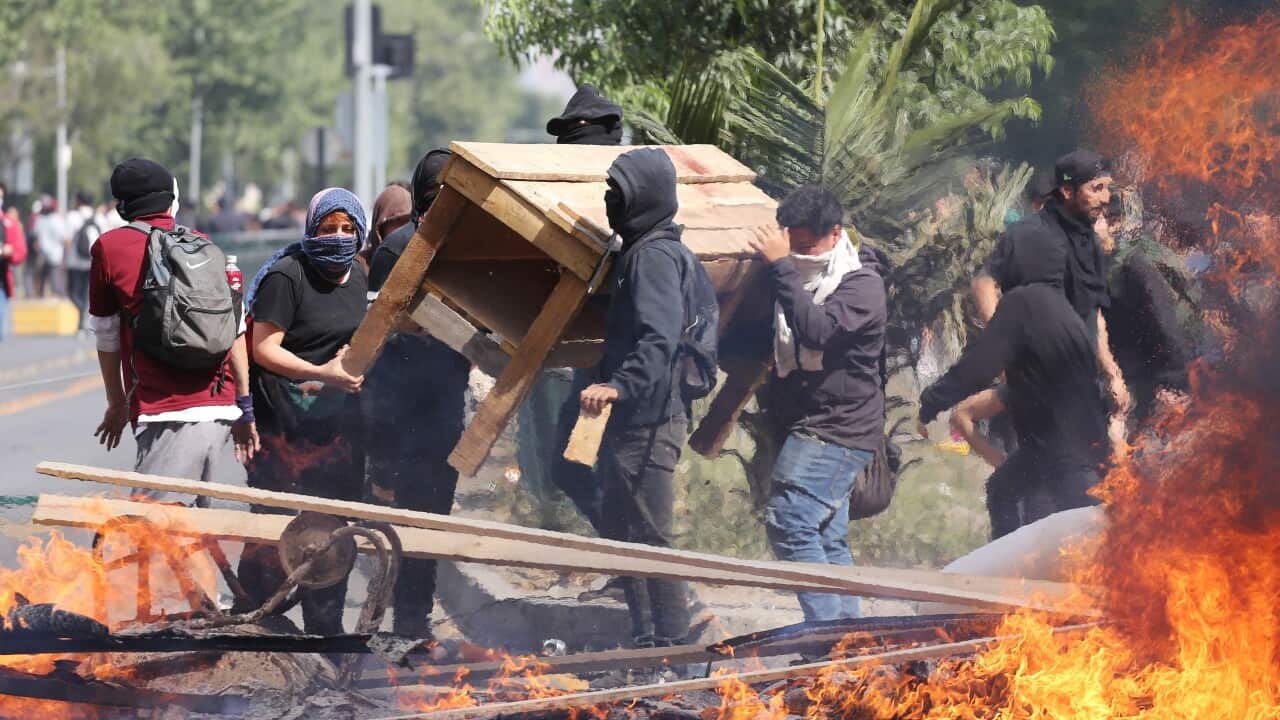 People burn objects as demonstrations against the increase of Metro fares take place, in Santiago, Chile, 19 October 2019.
