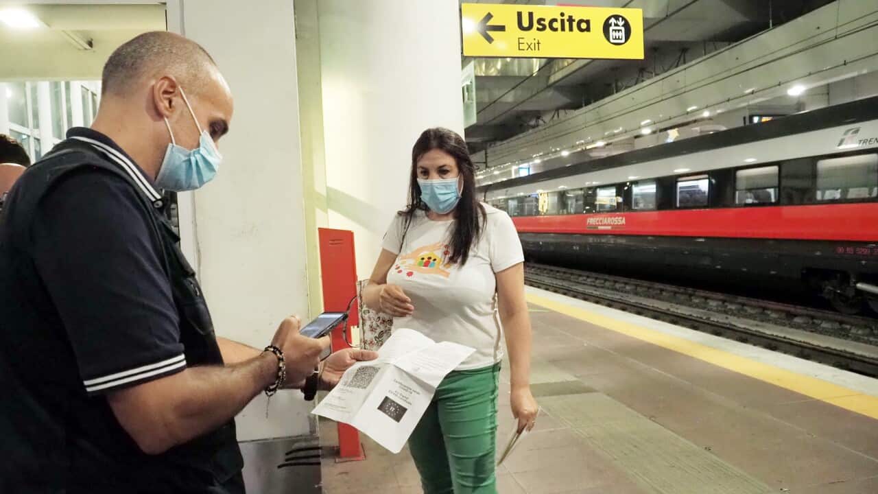 A traveller has her Green Pass checked at Bologna station, Italy