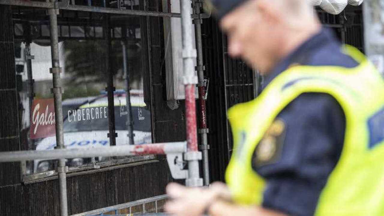 Police investigate the scene following a shooting outside an Internet Cafe in southern Sweden