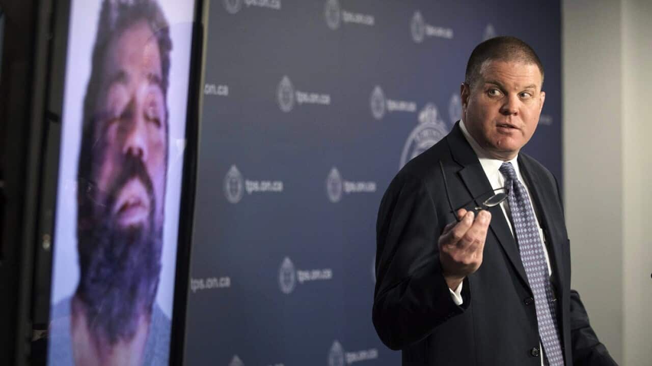 Hank Idsinga, lead investigator in the case against alleged serial killer Bruce McArthur, stands with a photo of an unidentified man.