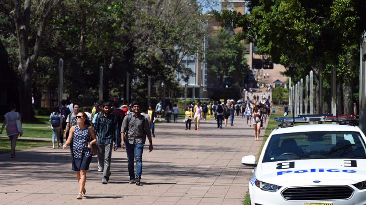 Students pass a police car at the University of NSW
