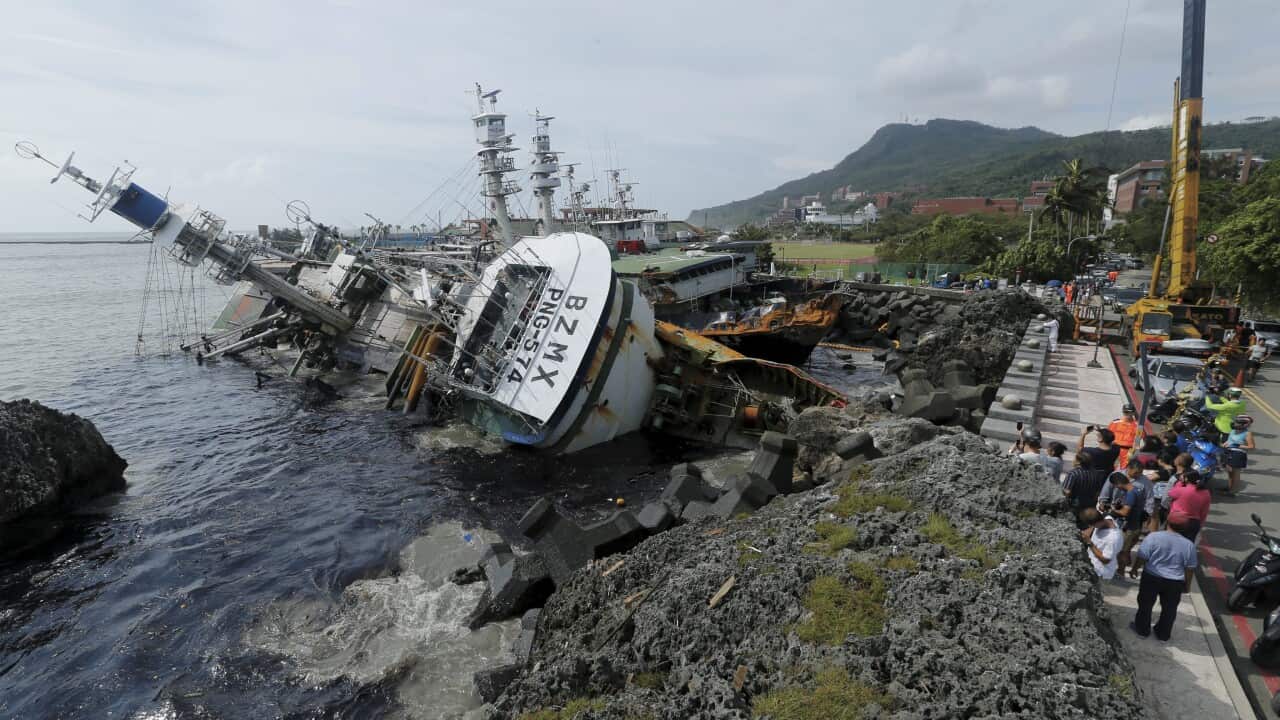People view sinking fishing vessels caused by super typhoon Meranti in Kaohsiung city, southern Taiwan, 15 September 2016.