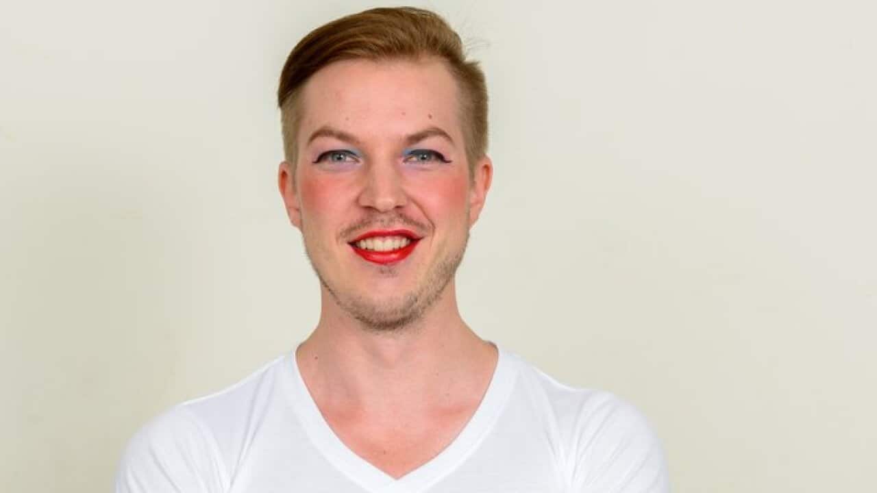 Smiling man wearing make up