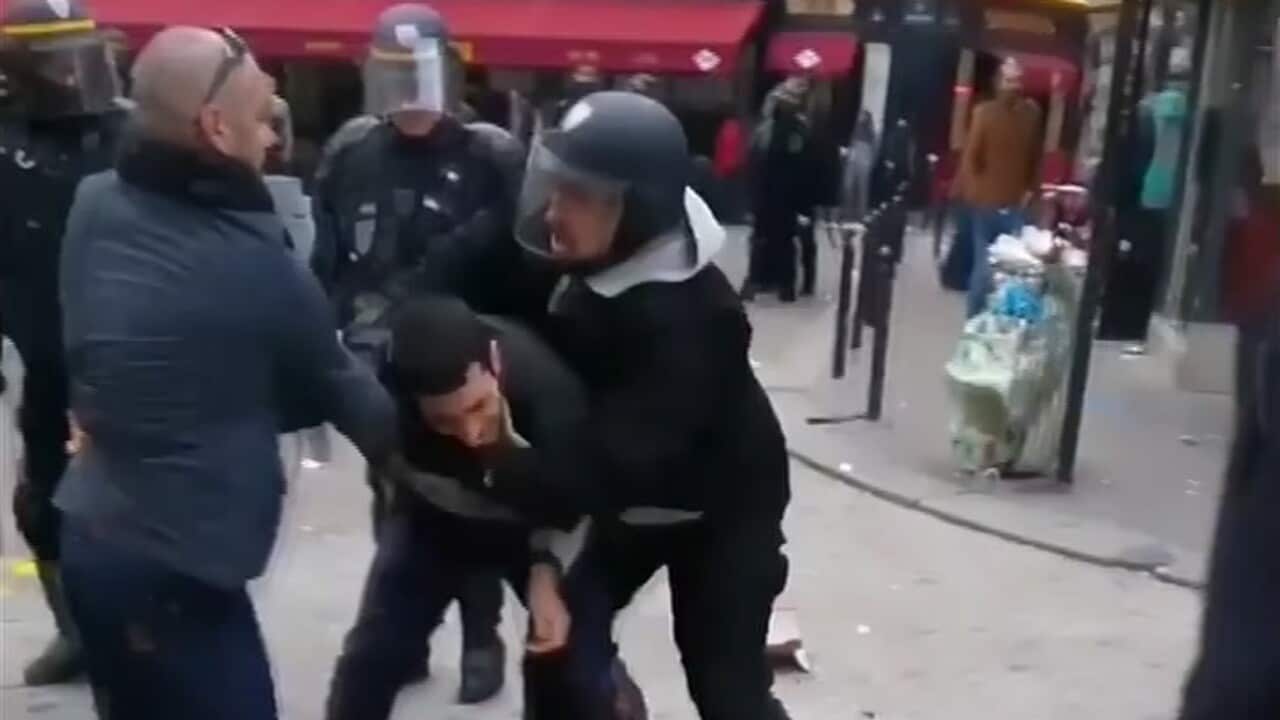 a man identified as Alexandre Benalla, right, a security chief to French President Emmanuel Macron, confronting a student during a May Day demonstration in Paris, May 1, 2018.