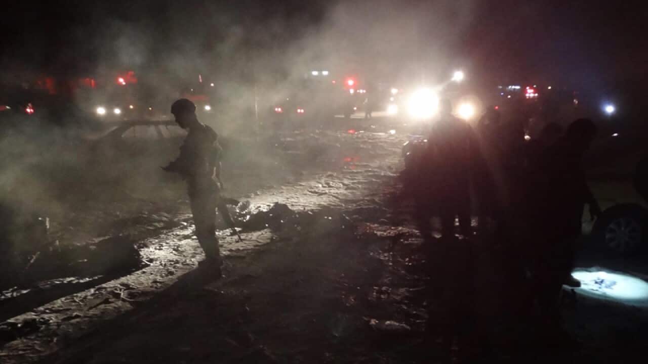 Iraqi youths inspect damages of a car bomb explosion in Iraq