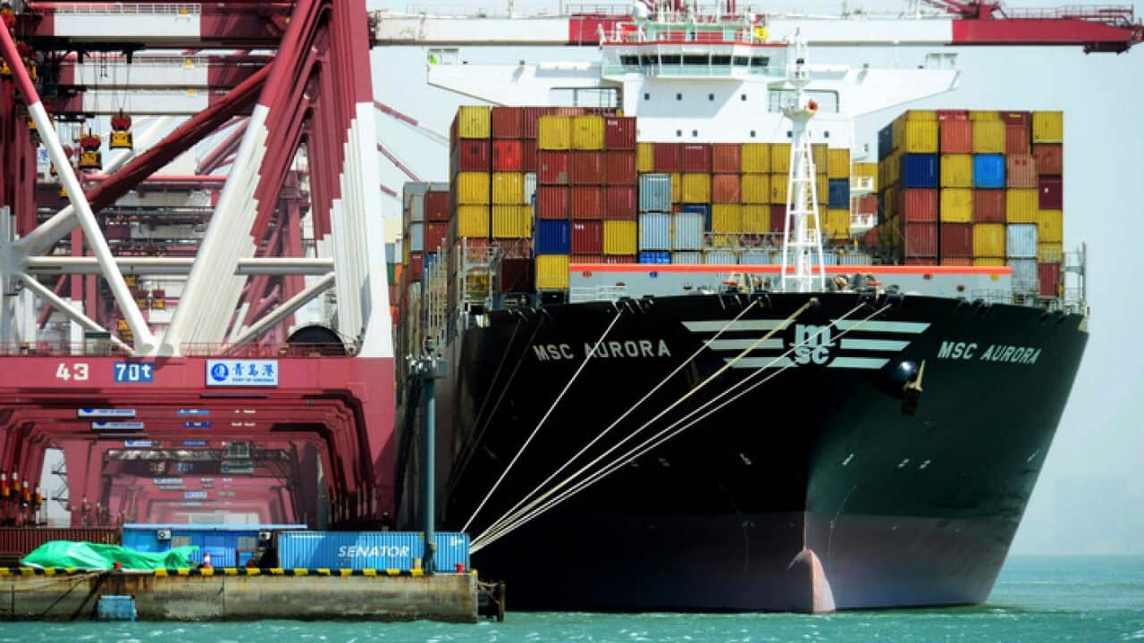 Containers are loaded onto a cargo ship at the port in Qingdao in east China's Shandong province.
