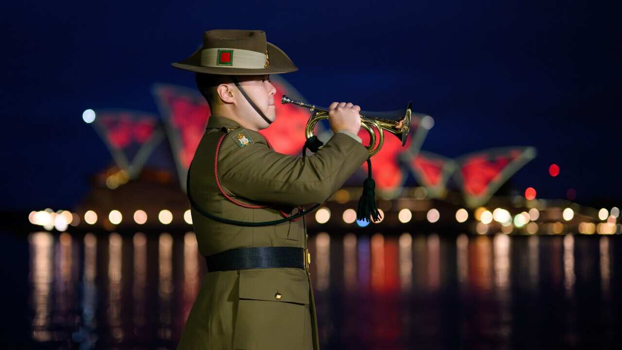 A large group of people standing at a basketball court that's serving as a voting centre.