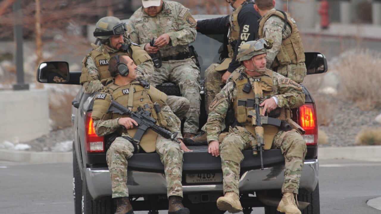 SWAT team members are trucked to where a gunman shot at four people