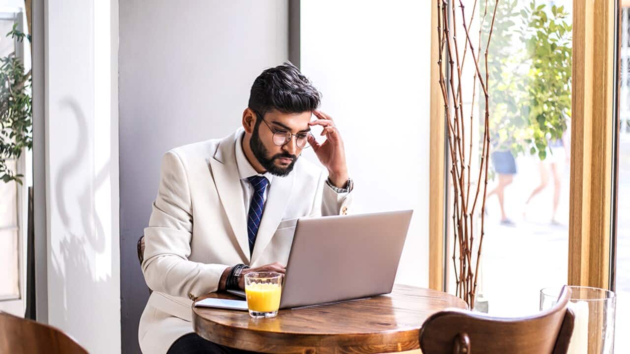 Young successfull businessman working in city cafe.