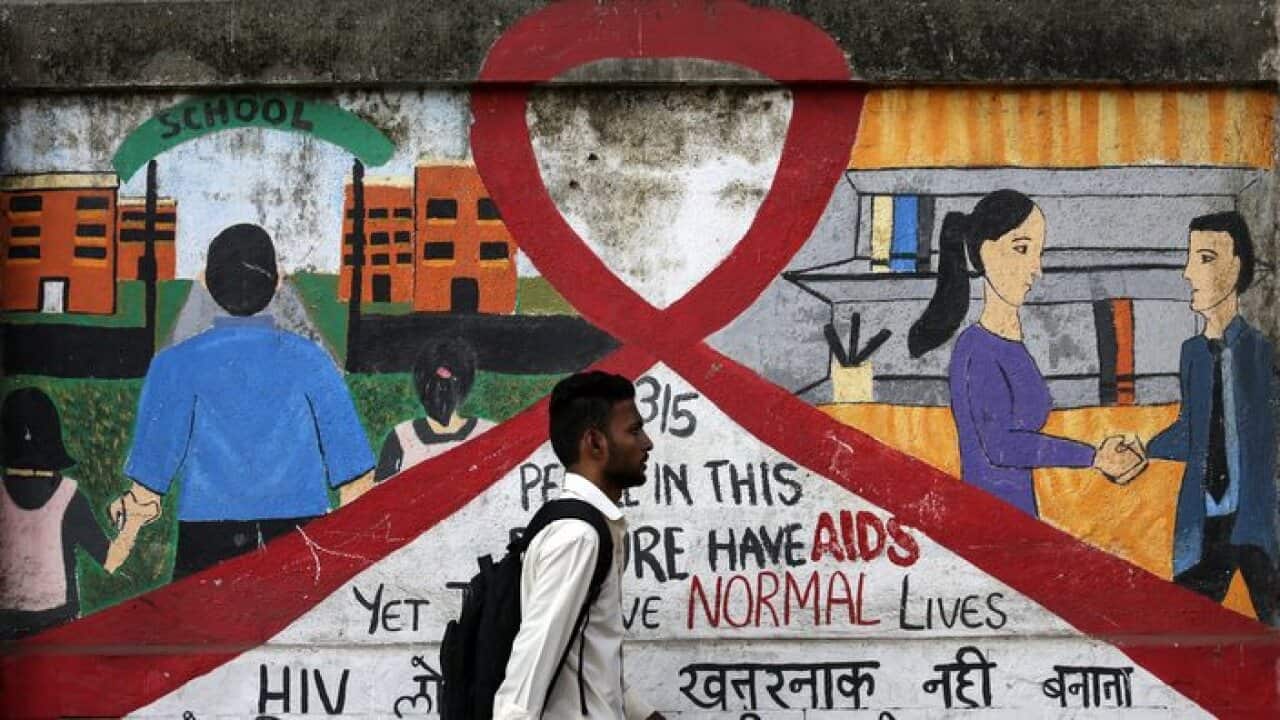 A man walks past a mural with a red ribbon symbolized HIV/AIDS awareness on the occasion of World Aids Day in Mumbai, India, 01 December 2016.