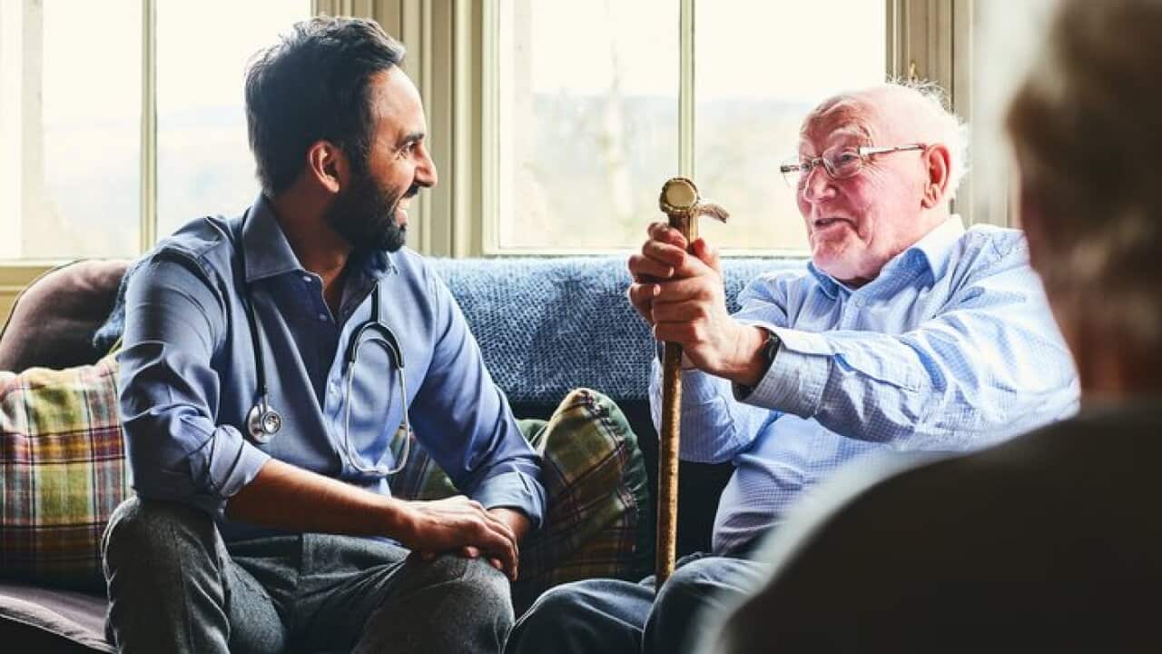 Smiling doctor visiting senior man at home